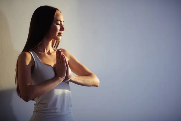 Frau praktiziert Yoga und Meditation, hält Handflächen in namaste mudra zusammen — Stockfoto