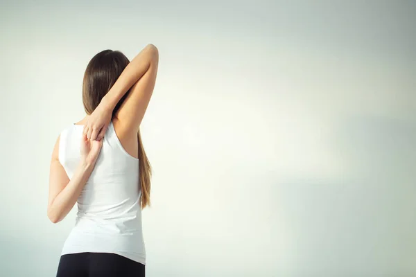 Visão traseira da mulher apta fazendo gomukhasana na aula de ioga — Fotografia de Stock