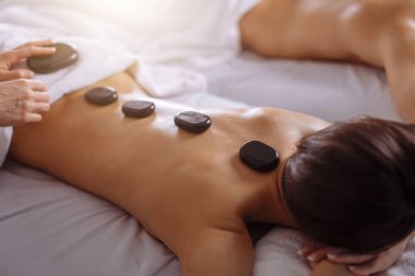 Sıcak taş masajı sahip spa salonda çift