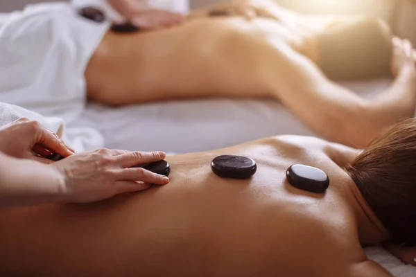 Pareja relajada recibiendo terapia de piedra caliente en el spa de belleza — Foto de Stock