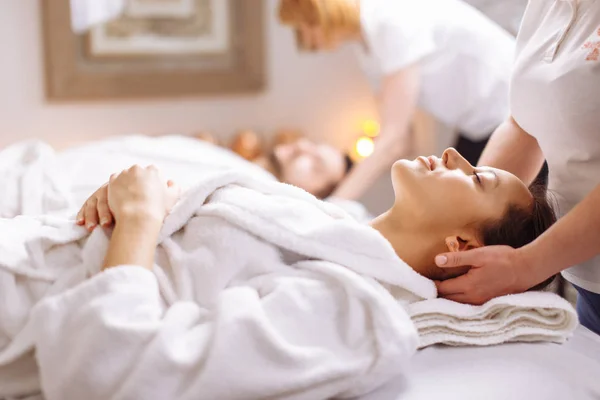 Young couple receiving head massage at beauty spa — Stock Photo, Image