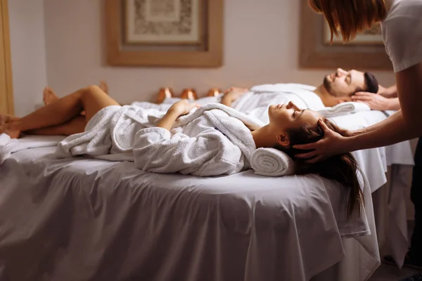 Giovane coppia riceve massaggio alla testa al centro benessere di bellezza — Foto Stock