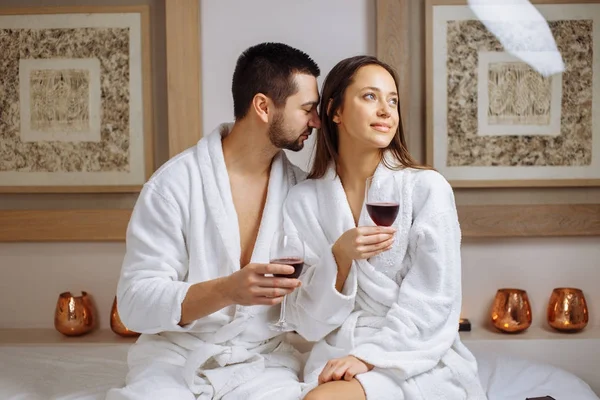 Casal em um spa de luxo degustando um copo de vinho branco — Fotografia de Stock