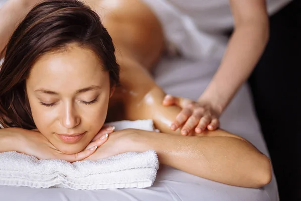 Relajante mujer consiguiendo spa masaje de hombro en salón de belleza —  Fotos de Stock