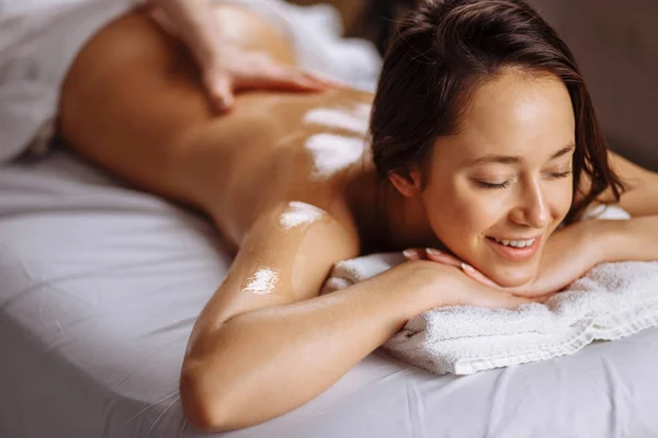 Bella donna che riceve un massaggio rilassante alla schiena al centro benessere . — Foto Stock