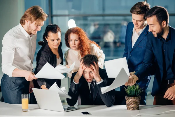 Stressed Business Man In Office surrounded by colleagues with documents in hands — Stock Photo, Image