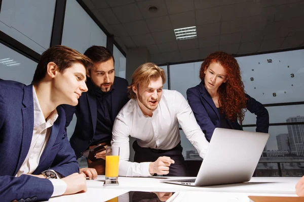 Lachende vrouwelijke en knappe mannelijke collega's zitten aan tafel, kijken naar Laptop — Stockfoto
