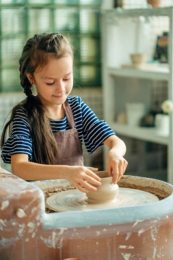 Çocuk kil pot sculpts. çömlekçi çarkında modelleme.