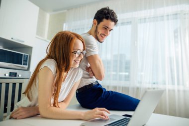 Dizüstü bilgisayarı olan çift evde vakit geçiriyor.