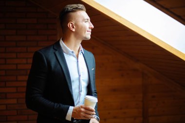 Evde kahve içme ve uzak seyir yakışıklı işadamı