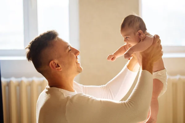 Vader met schattige baby dochter op bed liggen — Stockfoto