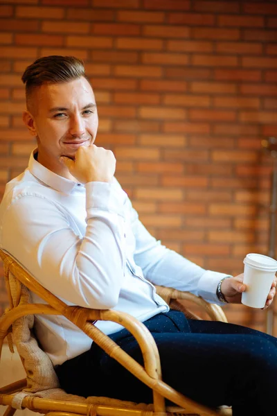 Guapo hombre de negocios bebiendo café en casa y mirando cámara — Foto de Stock
