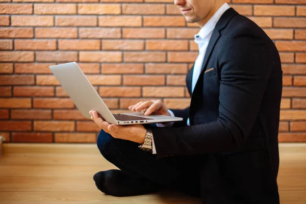 Zakenman met behulp van laptop thuis zittend op de vloer — Stockfoto