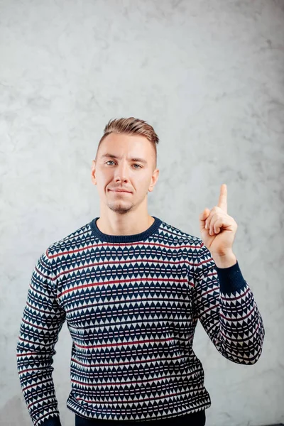 Jongeman richtingen wijzen op getextureerde betonnen muur achtergrond — Stockfoto