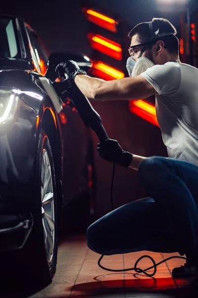 Detalles del coche - hombre con pulidor orbital en taller de reparación de automóviles. Enfoque selectivo . — Foto de Stock