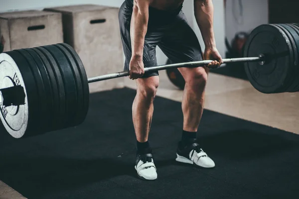 Athlete wearing black shorts lifting big barbell — Stock Photo, Image