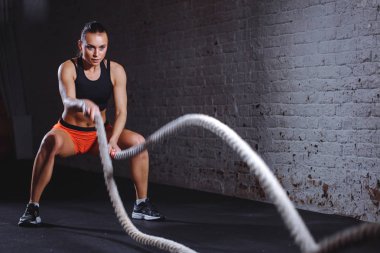Kadın yapmak egzersiz fonksiyonel eğitim salonunda savaş iple
