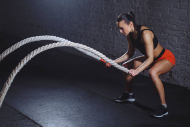 Atletik kadın savaş ip spor salonunda yapıyor