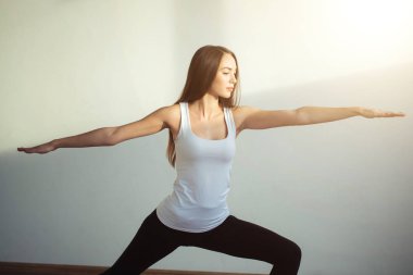 pratik yoga, savaşçı bir egzersiz, Virabhadrasana duran kadın