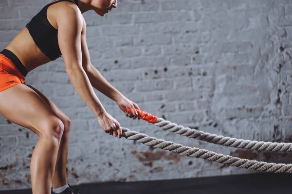 Close up photo of Athletic woman doing battle rope exercises at gym — Stock Photo, Image
