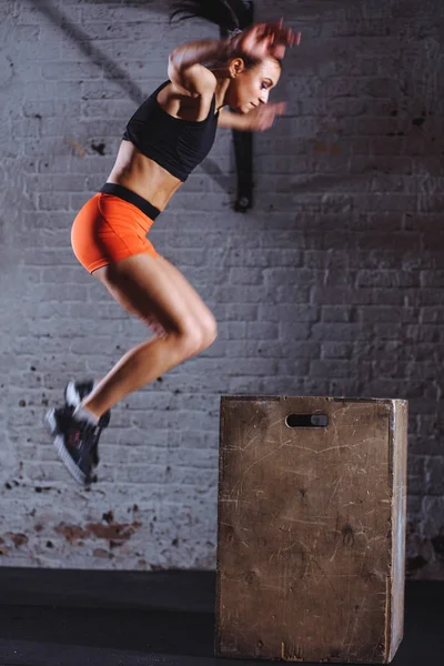 Femme boîte sautant à la gym cross fit. athlète faisant des sauts de boîte exercice à la salle de gym — Photo