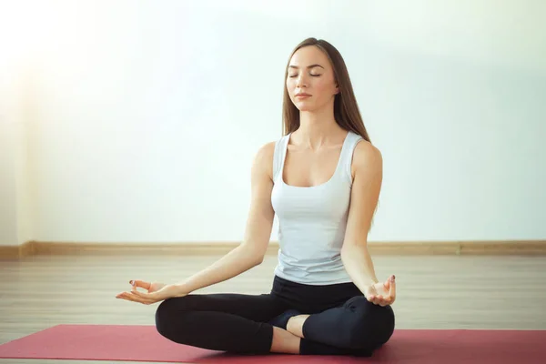 Mujer joven medita mientras practica yoga — Foto de Stock