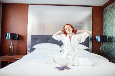 Uyanma sonra yatakta uzanan kızıl saçlı kadın