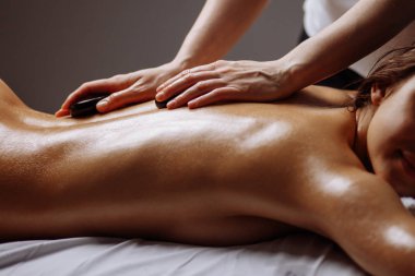 genç kadın sıcak taş spa salonunda masaj.