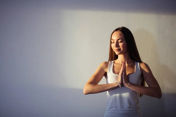 Жінка практикує йогу і медитацію, тримає долоні разом в імастерах мудра — стокове фото