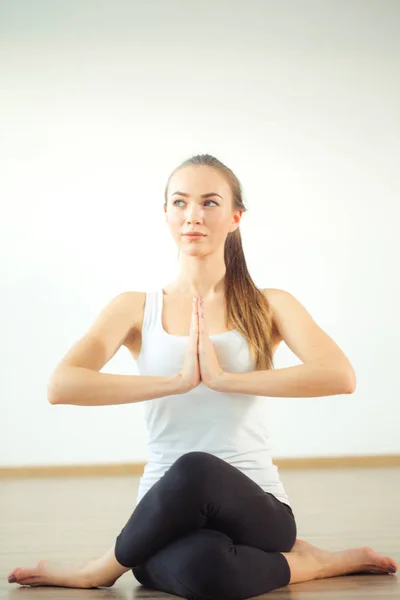 Mujer sonriente estirando la pierna en la estera en el gimnasio — Foto de Stock