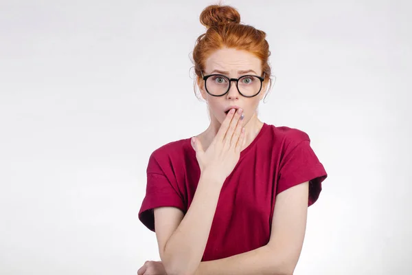 Femme choquée dans des lunettes regardant la caméra avec la bouche ouverte et la tête touchante — Photo