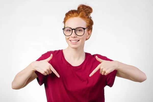 Cute redhead girl pointing down at copyspace — Stock Photo, Image