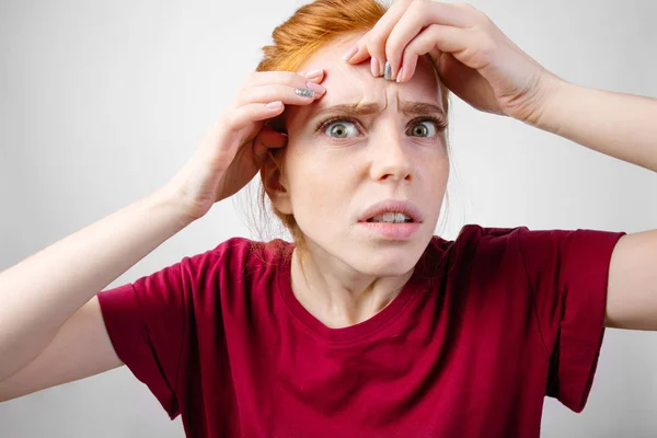 Redhead woman squeezing her pimples, removing pimple from her face — Stock Photo, Image