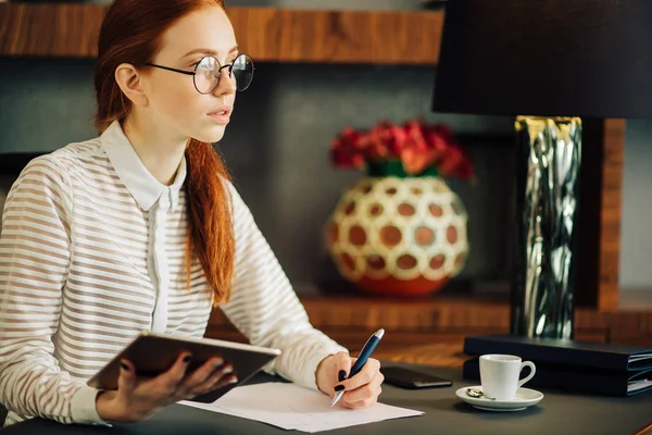 Vrouw schrijven op papier met digitale tabletcomputer in kantoorruimte — Stockfoto