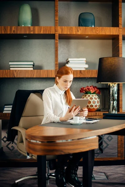 Businesswoman wearing glasses using digital tablet in office