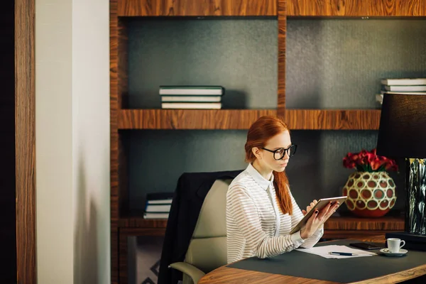 Empresaria con gafas usando tableta digital en la oficina — Foto de Stock
