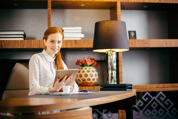 Mulher bonita segurando tablet digital e olhando para a câmera com sorriso — Fotografia de Stock