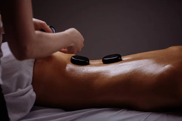 Donna ottenere massaggio con pietre calde nel salone spa. concetto di trattamento di bellezza — Foto Stock
