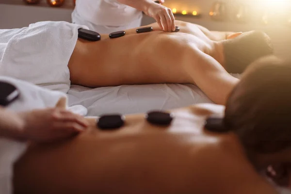 Pareja relajada recibiendo terapia de piedra caliente en el spa de belleza — Foto de Stock