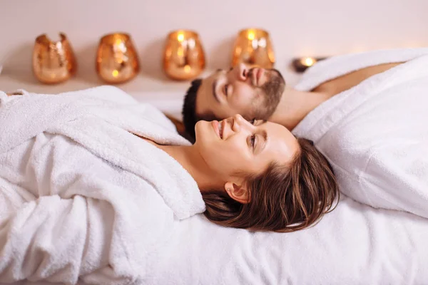 Erkek ve kadın üzerinde uzanmış yataklar lüks spa ve sağlıklı yaşam merkezinde masaj — Stok fotoğraf