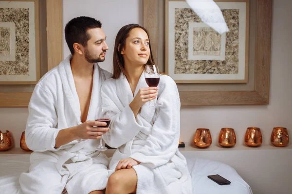 Pareja en un spa de lujo degustación de una copa de vino blanco — Foto de Stock