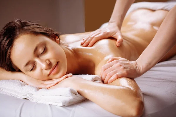 Relaxing woman getting spa massage of shoulder in beauty salon — Stock Photo, Image