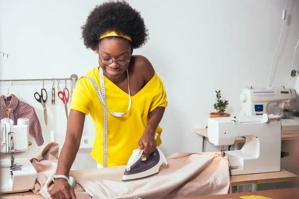 Afrikaanse vrouw naaister strijkdoek — Stockfoto