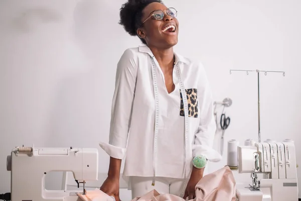 Lachende Näherin näht im Atelier — Stockfoto