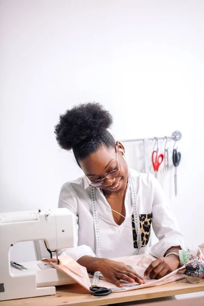 African seamstress working with fabric takes measures — Stock Photo, Image