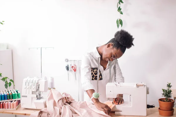 Costurera mujer sentado y cose en la máquina de coser. Dressmaker trabajando — Foto de Stock