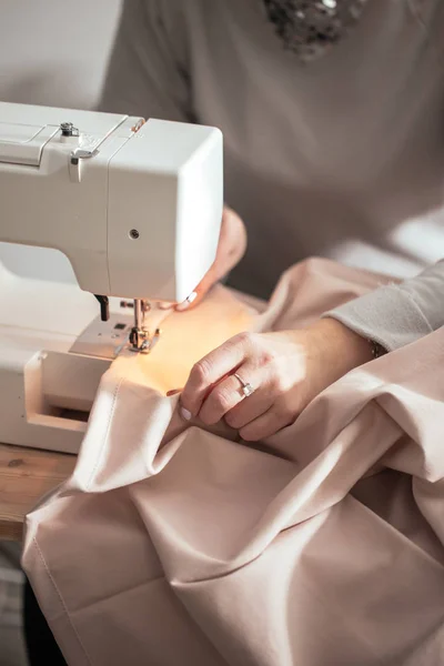Primer plano costurera manos trabajando en la máquina de coser en casa —  Fotos de Stock