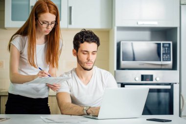 kadın hesaplamak veya hesapları kalemle, kocası dizüstü kullanarak yazmak