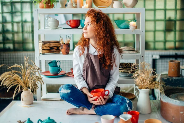 粘土の店でロータス ポーズで座っている赤毛の女性 — ストック写真