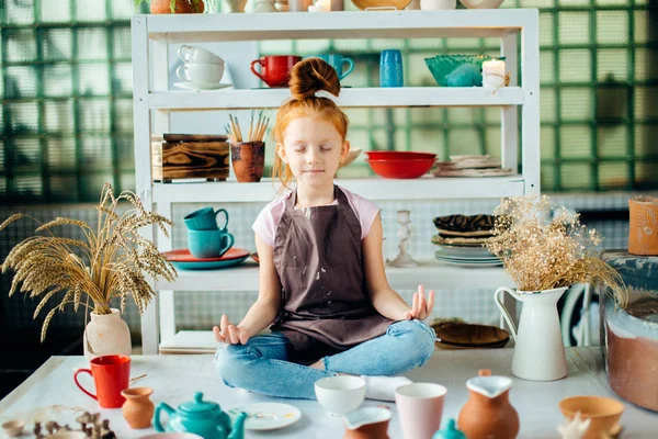 Девушка с много чашек из глины сидя в мастерской керамики — стоковое фото